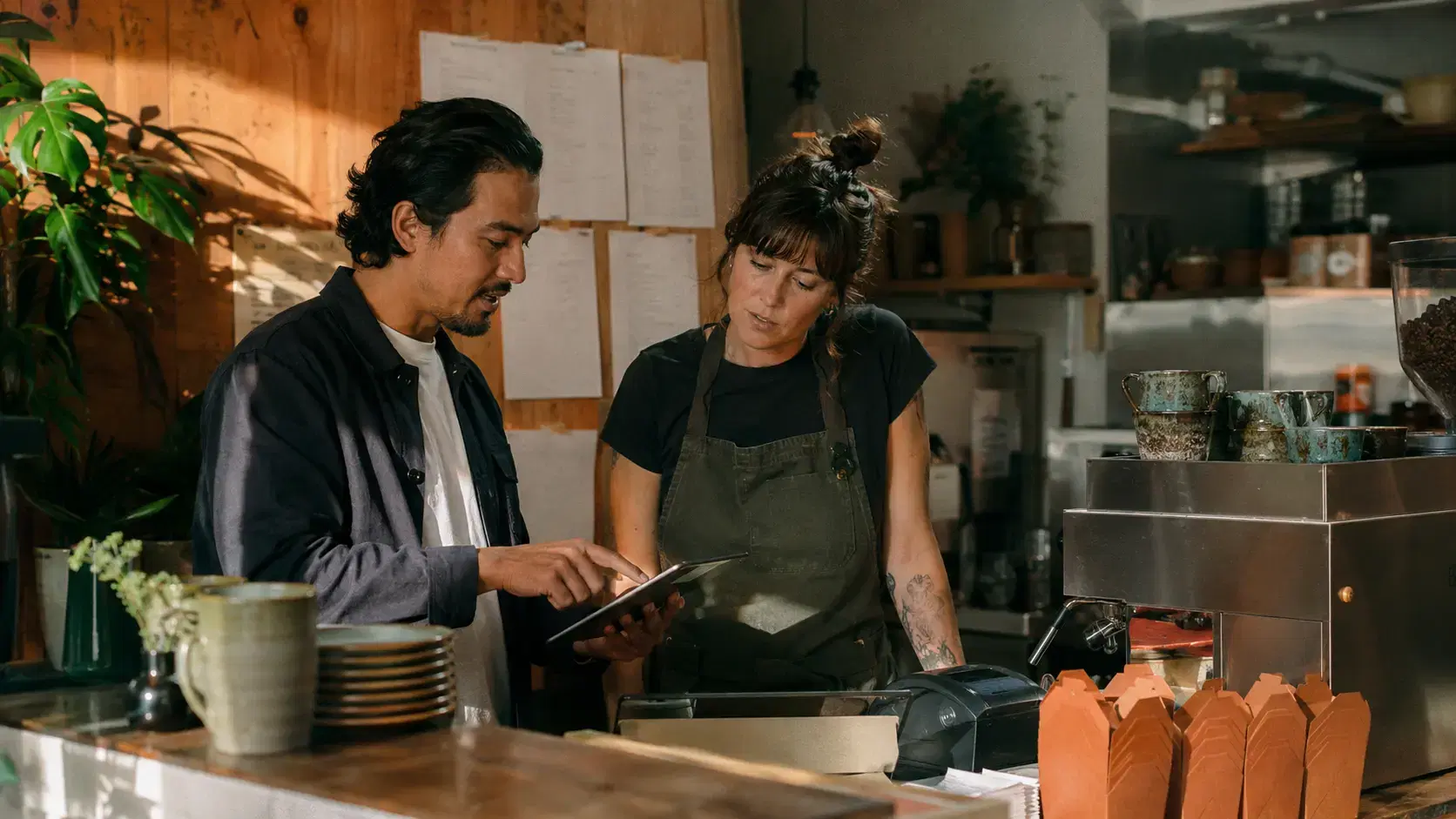 A restaurant-tech partner running migrations from their workspace — laptop, notebook, and the tools of a partner moving a book of restaurants onto Ogent.
